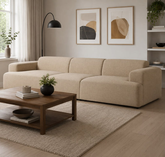 Beige sectional sofa in a living room with a wooden coffee table, rug, and wall art.