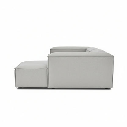 Side profile of Alpha 2 seater sofa with chaise end, showing its modular low-profile design in neutral fabric