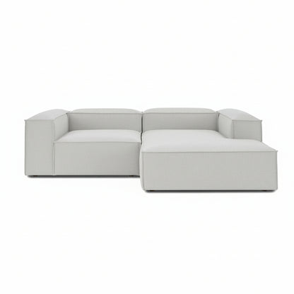 A clean-lined two-seater with an integrated chaise extension, offering a relaxed lounging experience while maintaining the structured, modern aesthetic of the Alpha collection.