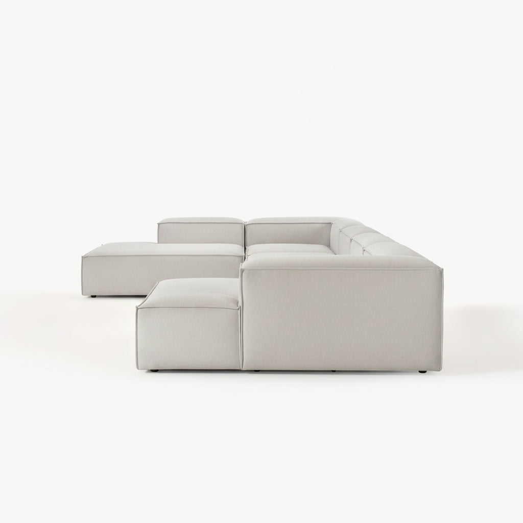 Alpha modular double corner sofa shown from the side, highlighting the integrated stool unit and structured form
