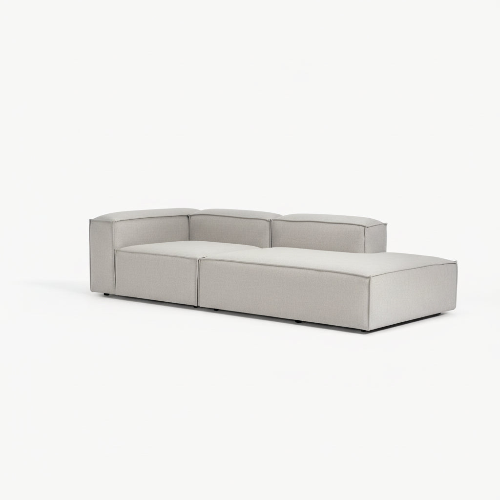 Alpha extended corner sofa configuration with chaise and modular sections in premium neutral fabric, defined by a low-profile and architectural form