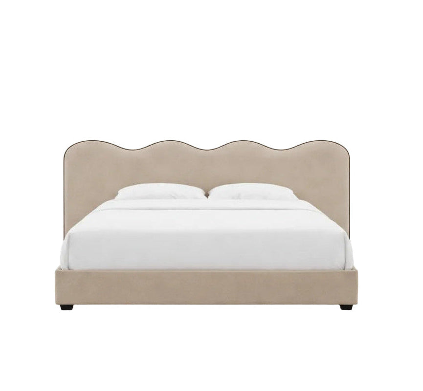 Elegant upholstered frame with a signature scalloped headboard and refined piping detail
