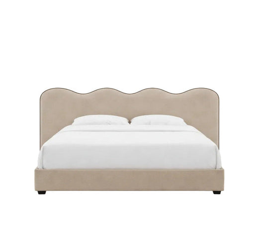 Elegant upholstered frame with a signature scalloped headboard and refined piping detail
