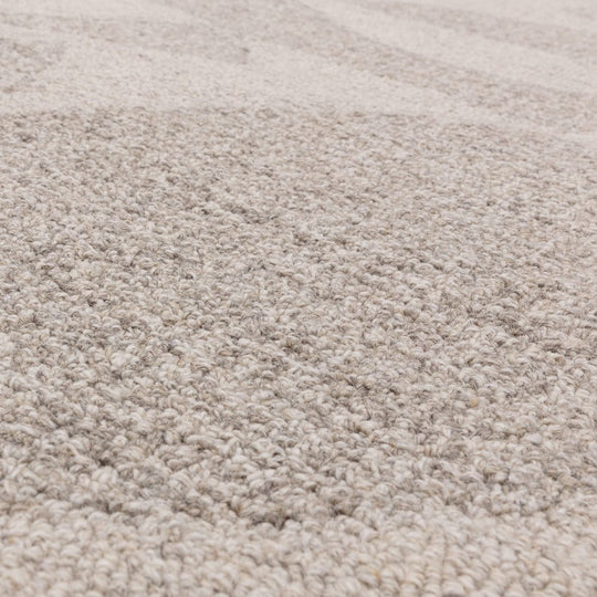 An angled studio shot of the Bellara Rug on a white background, focusing on its 100% wool weave, subtle pattern depth, and natural material variation.