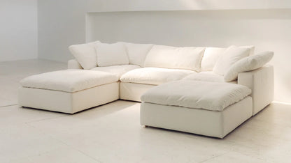 U shaped sofa with oversized cushions and two footstools creating a relaxed lounge feel
