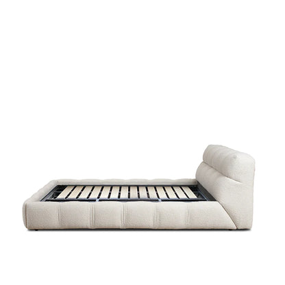 dona bed with vertical panelled headboard and soft neutral upholstery