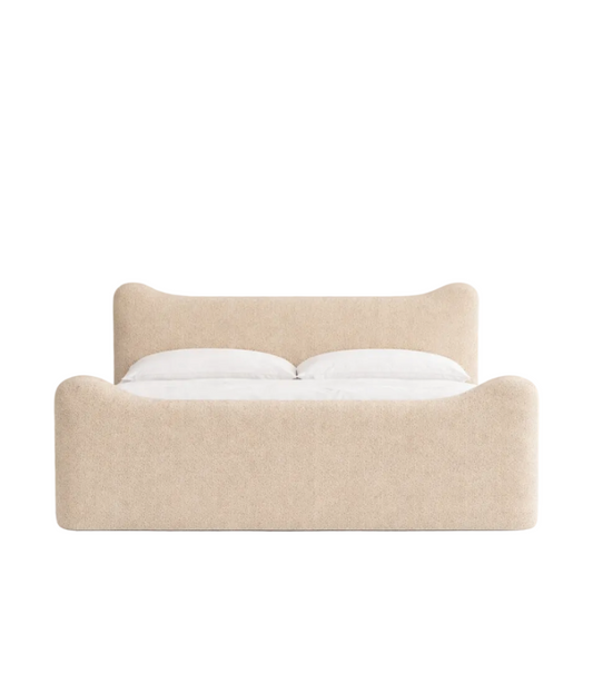 Contemporary upholstered bed frame with curved headboard and rounded footboard in soft neutral fabric
