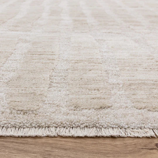 An angled detail shot highlighting the refined edge finish and cotton backing of the Fiora Rug, showcasing its machine-woven craftsmanship and structural quality.