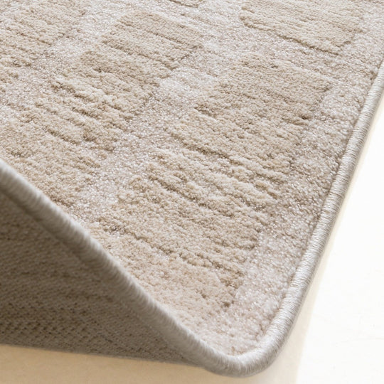 A detailed macro shot showcasing the Fiora Rug’s 100% wool fibres, highlighting its gentle tonal variation, organic colour movement, and soft cut pile texture on a white background.