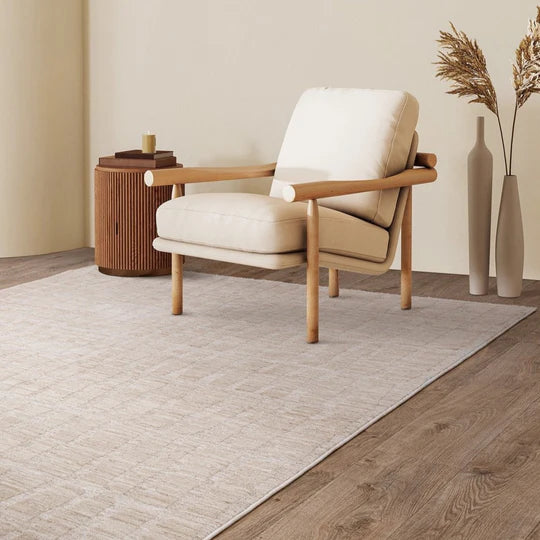 A studio angled view emphasizing the Fiora Rug’s subtle tonal variation, natural beige palette, and organic wool texture, captured on a clean white background.