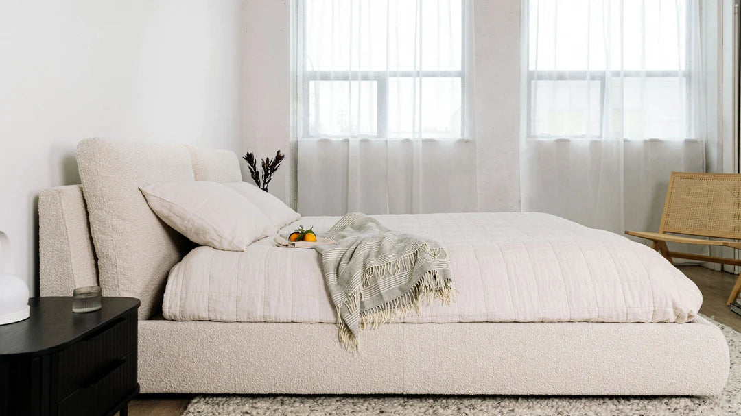 modern upholstered bed with low profile base and neutral finish