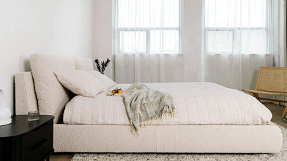 modern upholstered bed with low profile base and neutral finish