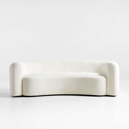 A beige, fabric-covered sofa with a solid hardwood frame and hidden black plastic legs, presented in a curved, streamlined style.