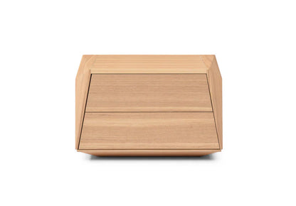 The Vertu Bedside Table is presented in a full studio view on a clean white background, showcasing its angular silhouette and refined ash oak veneer finish.